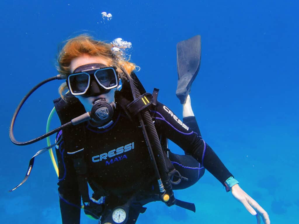 Wendy underwater in a field of blue