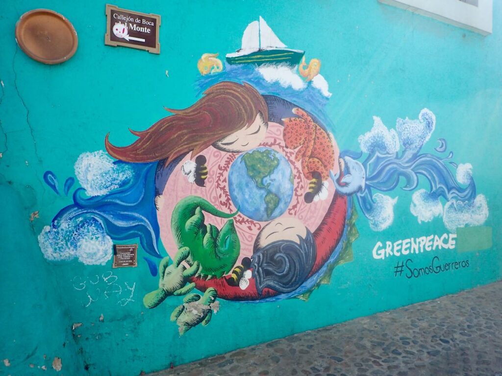 mural of earth, girl, and fetal animals with waves. "Greenpeace".